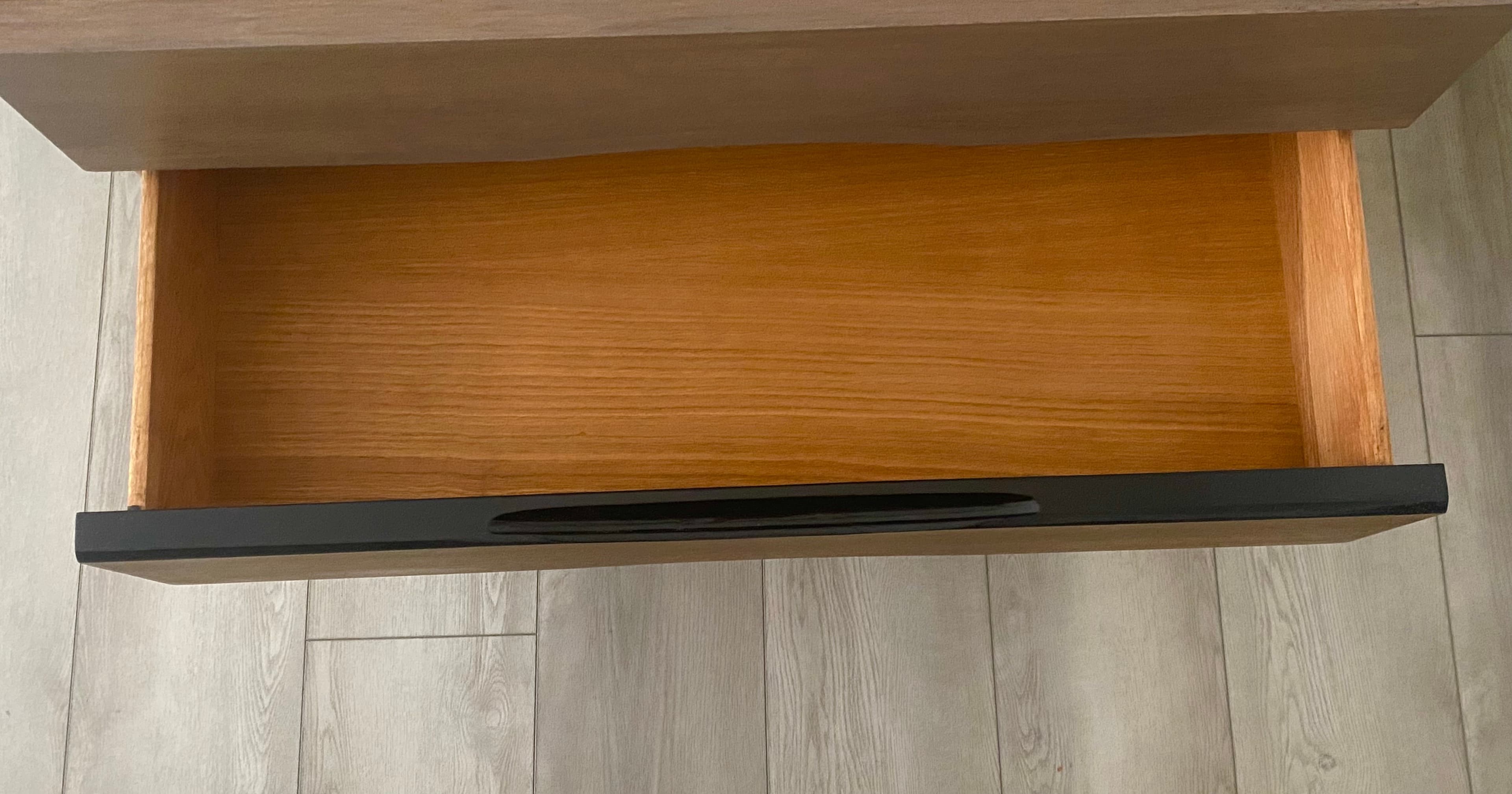 Open drawer interior on a walnut dresser.