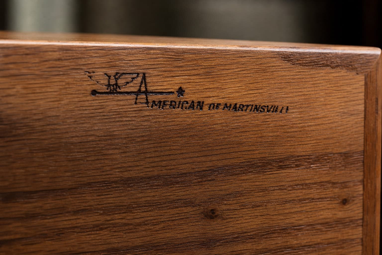 Close detail of a maker's mark on a walnut furniture piece.